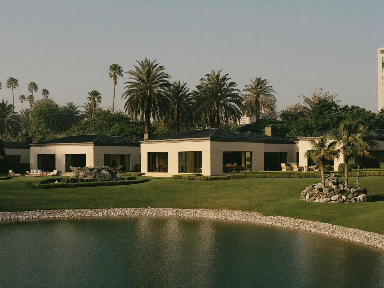 Family villas with green lawns beside a lake in The Meadows, Dubai