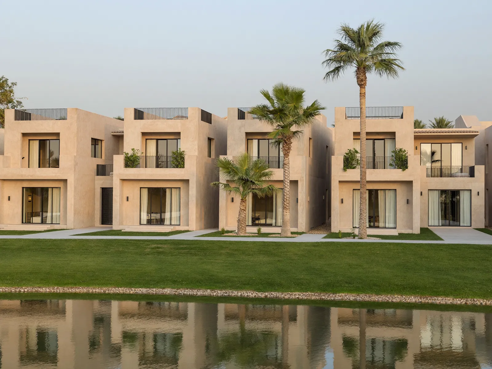 Row of beige townhouses beside a lake in The Springs, Dubai